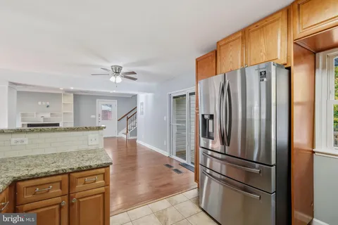 a kitchen with stainless steel appliances granite countertop a refrigerator and a stove top oven