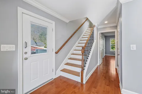 a view of a hallway with wooden floor and entryway