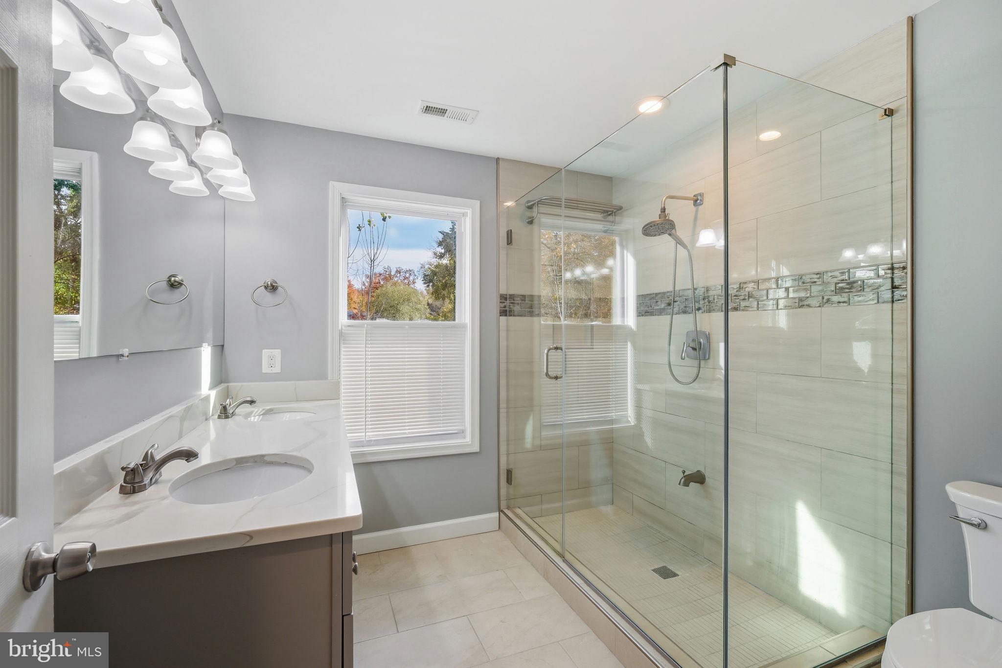 8817 Lagrange Street Lorton, VA 22079 - Photo 25 of 47 a bathroom with a shower sink vanity and mirror