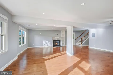 a view of a livingroom with wooden floor and kitchen space with a sink