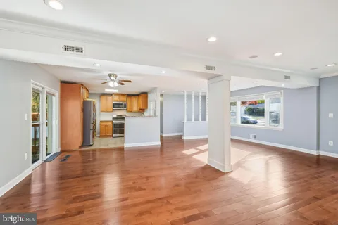 a view of a big room with wooden floor and windows