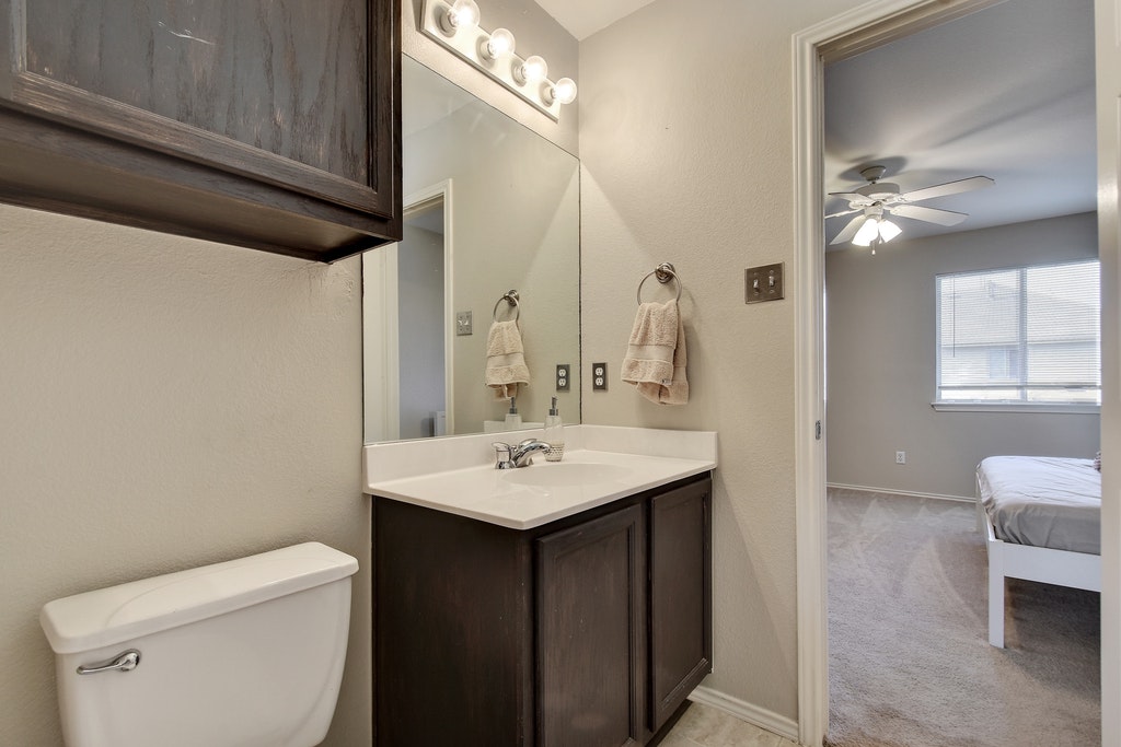 2201 Keepsake Drive Austin, TX 78745 - Photo 18 of 25 a bathroom with a sink a toilet and a mirror