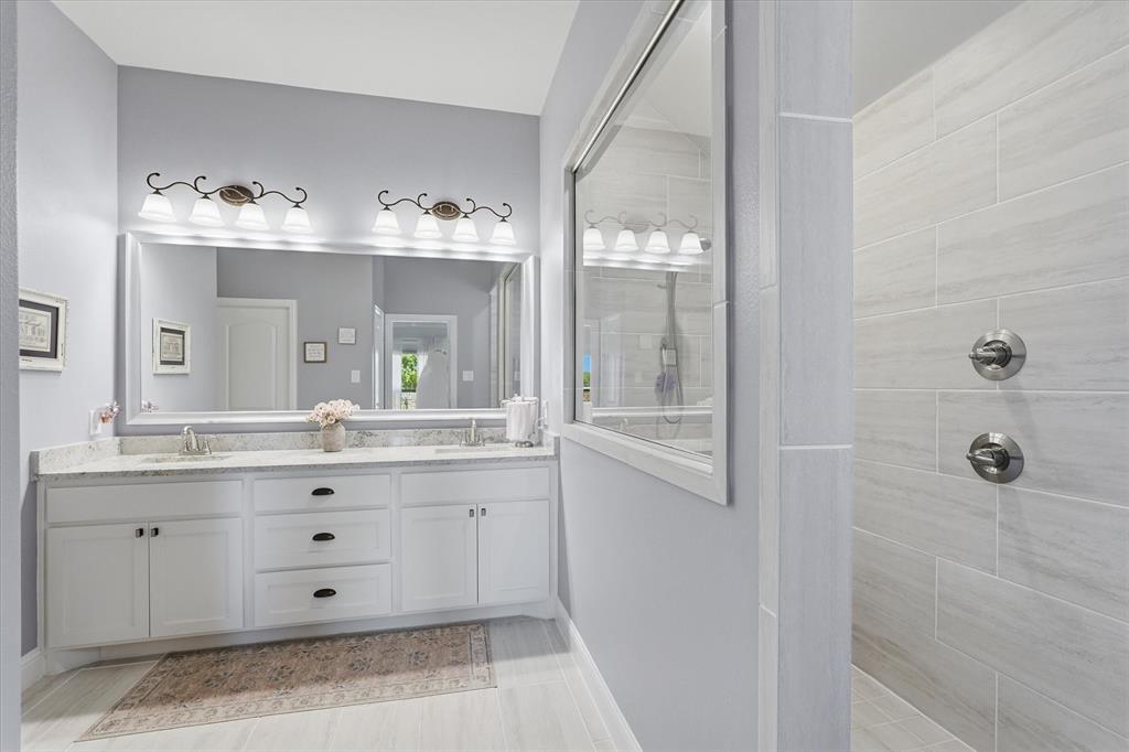 813 Mildren Lane Fate, TX 75087 - Photo 13 of 32 This amazing bathroom also features a full length, framed mirror and neutral tile throughout!