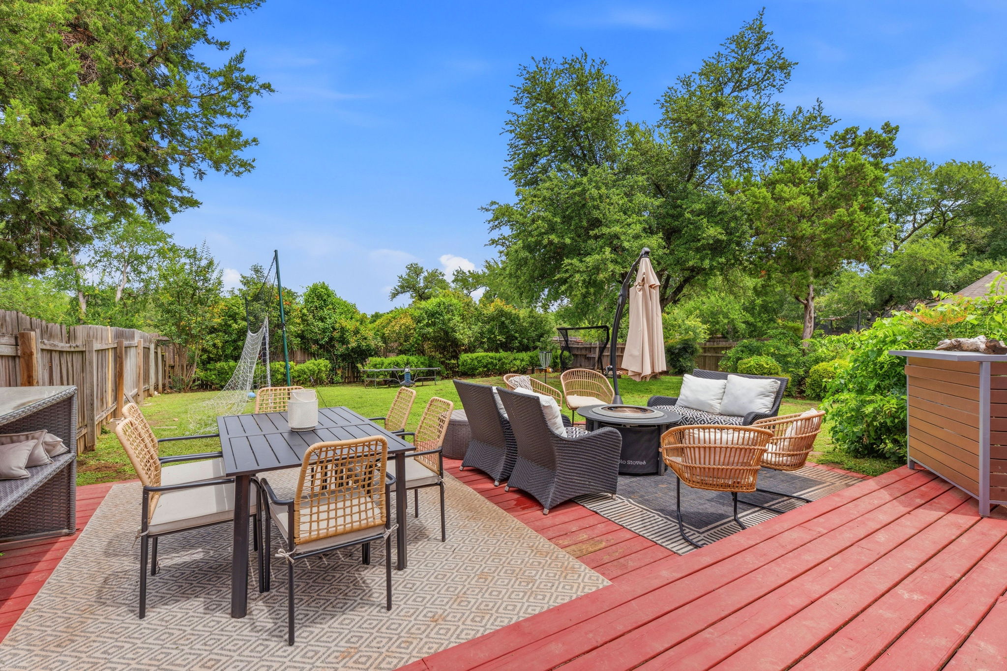 8317 Pommel Drive Austin, TX 78759 - Photo 23 of 26 An inviting backyard deck, featuring multiple seating areas, seamlessly connects to a spacious lawn.