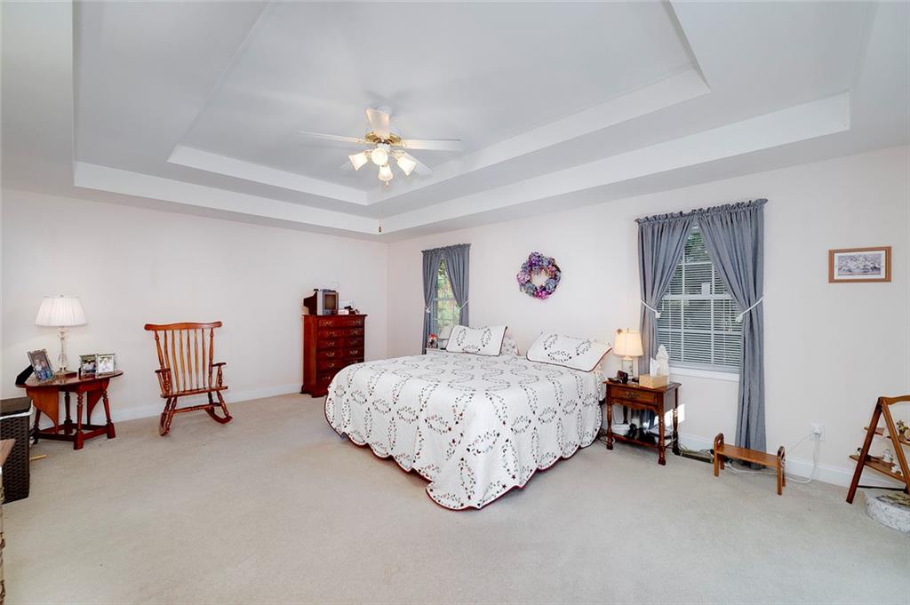 151 Courts Of Hampton Hampton, GA 30228 - Photo 30 of 54 a bedroom with bed and a chandelier