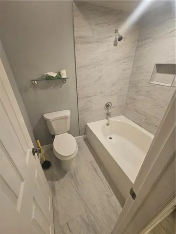 a white toilet sitting next to a bathroom sink