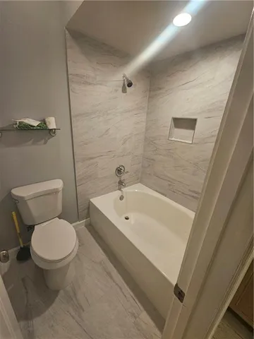 a white toilet sitting next to a bathroom sink and vanity