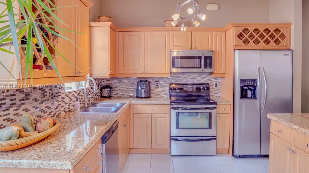 1701 Southeast 17th Avenue Homestead, FL 33035 - Photo 10 of 25 a kitchen with stainless steel appliances granite countertop a stove a sink and a refrigerator