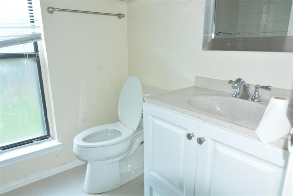 210 Apollo Road Garland, TX 75040 - Photo 16 of 23 White vanity with panel-front cabinetry, integrated sink, and chrome faucet