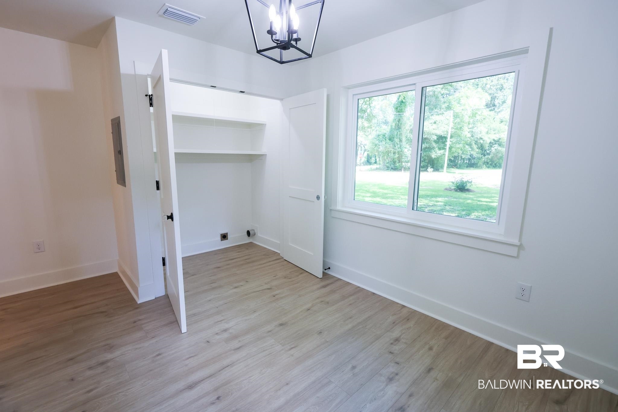 12190 Pecan Grove Street Magnolia Springs, AL 36555 - Photo 14 of 45 Unfurnished bedroom featuring light wood-type flooring and an inviting chandelier