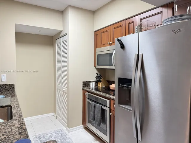 a kitchen with stainless steel appliances granite countertop a refrigerator and a stove
