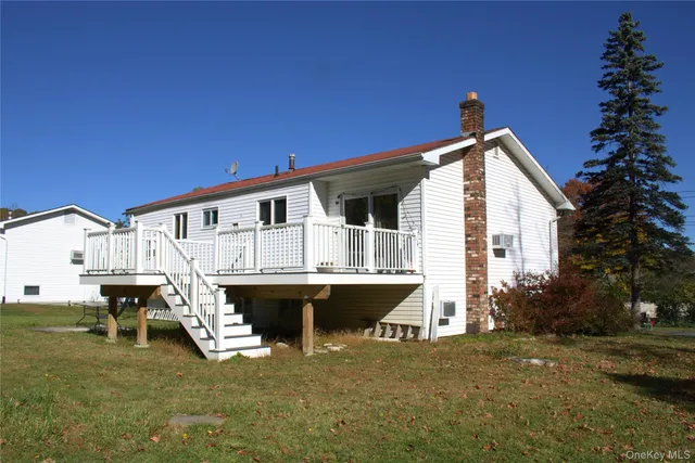 a view of a house with wooden deck and furniture
