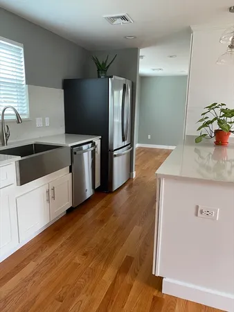 a kitchen with granite countertop a refrigerator and a sink