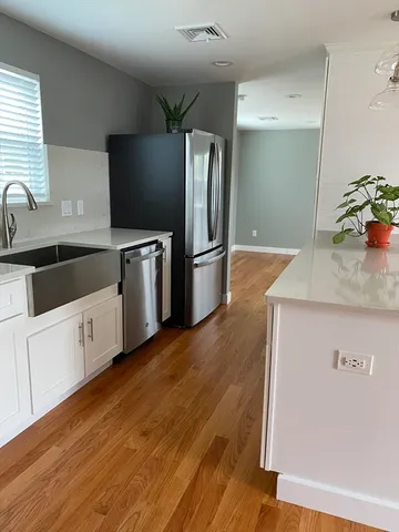 a kitchen with granite countertop a refrigerator and a sink