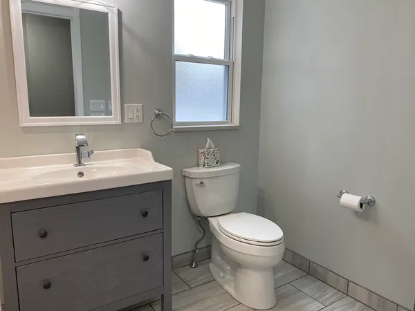 a bathroom with a toilet sink and mirror