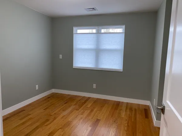 a view of room with window and wooden floor