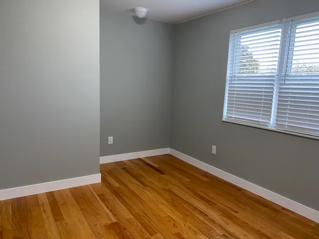 a view of a room with wooden floor and a window