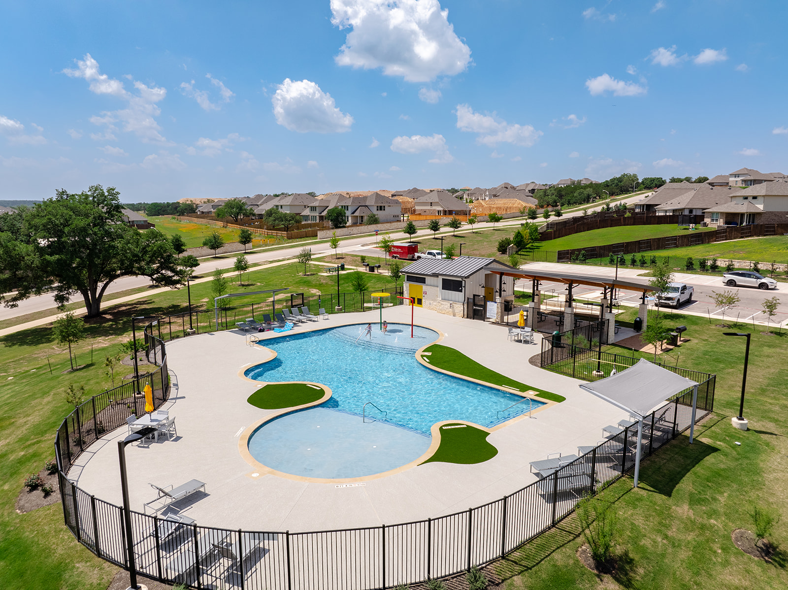 900 Balsora Cove Georgetown, TX 78628 - Photo 35 of 39 A vibrant community pool offers refreshing recreation for residents amidst a picturesque neighborhood backdrop.