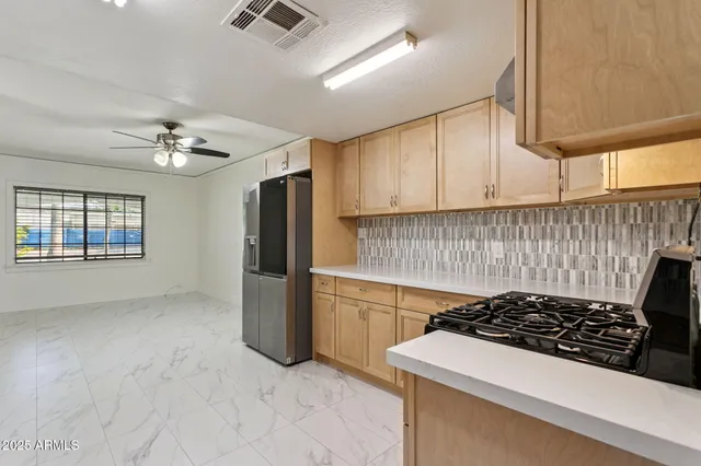 a large kitchen with stainless steel appliances granite countertop a stove a sink and a refrigerator