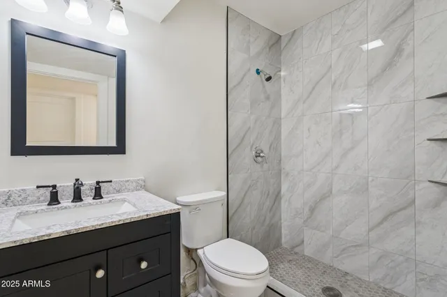 an empty room with chandelier fan and windows