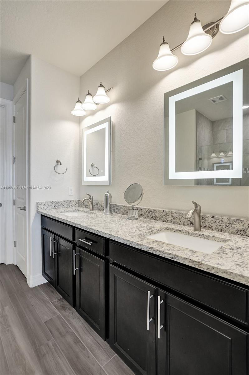 5055 Eucalyptus Drive Hollywood, FL 33021 - Photo 22 of 50 a bathroom with a granite countertop sink a large mirror and a