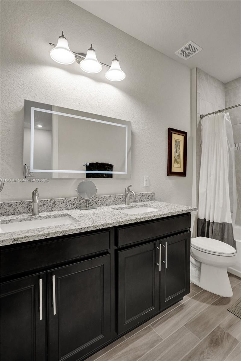 5055 Eucalyptus Drive Hollywood, FL 33021 - Photo 36 of 50 a bathroom with a double vanity sink and a mirror