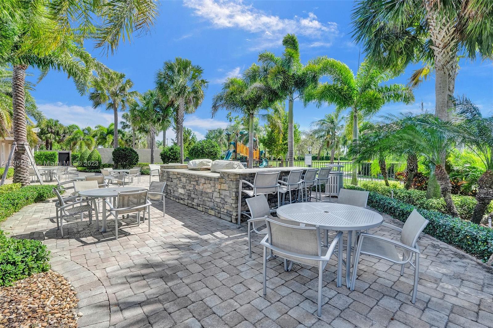 5055 Eucalyptus Drive Hollywood, FL 33021 - Photo 47 of 50 a view of a patio with table and chairs potted plants and palm tree