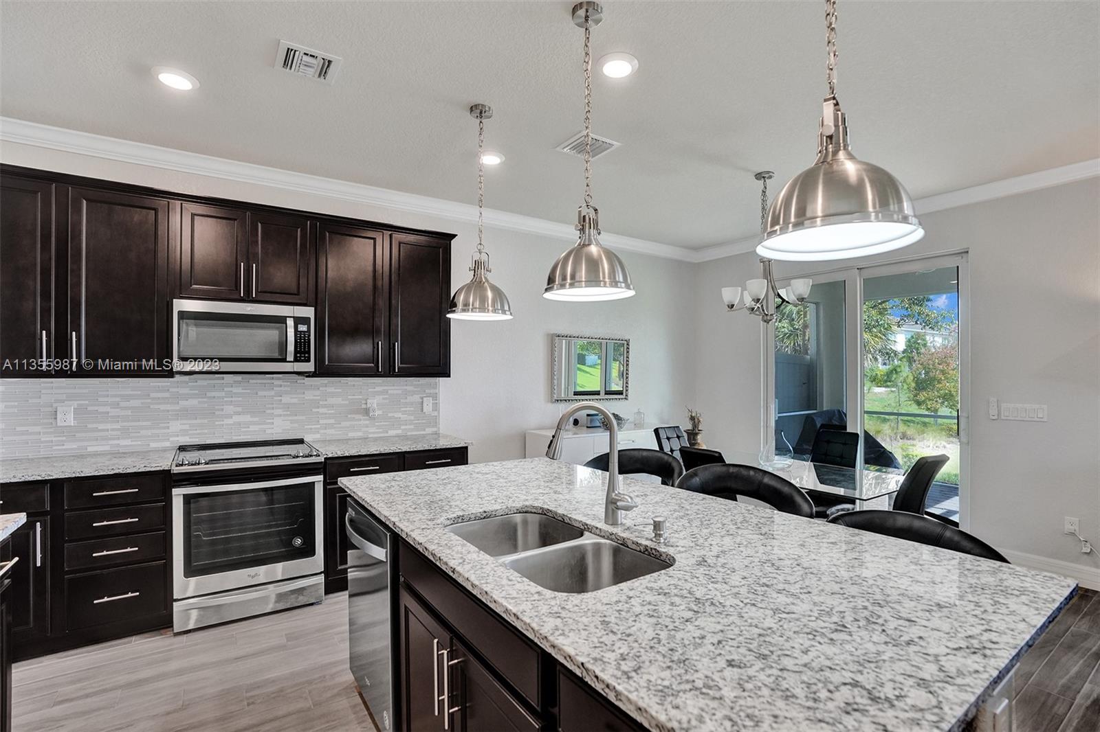 5055 Eucalyptus Drive Hollywood, FL 33021 - Photo 7 of 50 a kitchen with stainless steel appliances granite countertop a sink dishwasher a stove and a refrigerator with wooden floor