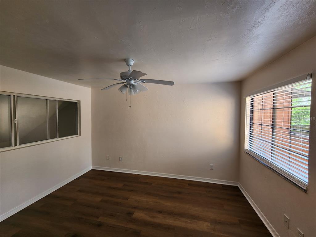5823 Southwest 9th Place, Unit H55 Gainesville, FL 32607 - Photo 39 of 50 a view of an empty room with wooden floor and a window