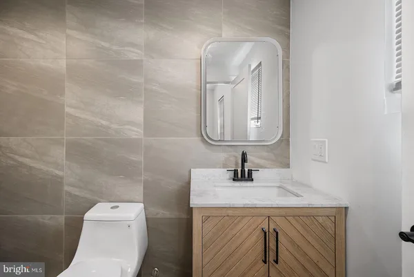 a bathroom with a sink vanity and toilet