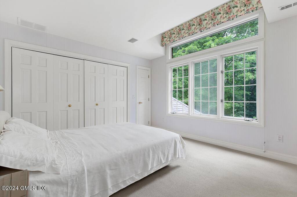 158 Clapboard Ridge Road Greenwich, CT 06831 - Photo 29 of 41 a large bed sitting in a bedroom next to a window