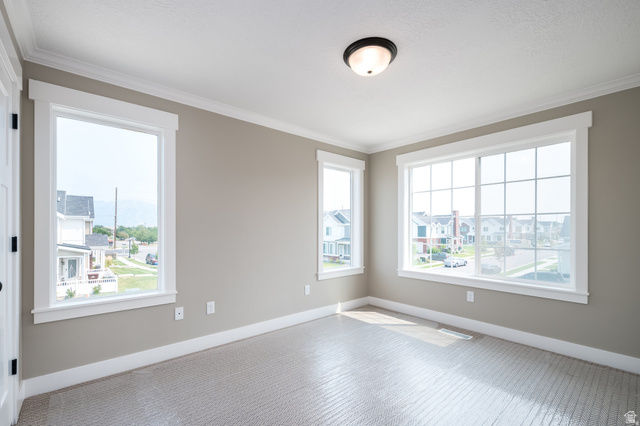801 East Cys Road, Unit 19 Sandy, UT 84094 - Photo 7 of 11 Room featuring three windows with white trim, light gray walls, and textured carpet flooring
