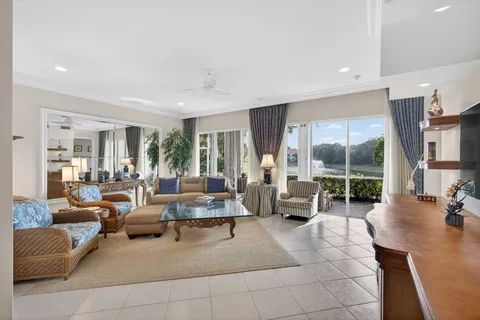 a living room with furniture kitchen view and a large window