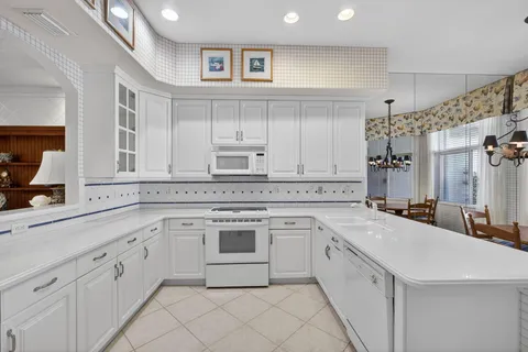 a kitchen with white cabinets and white appliances