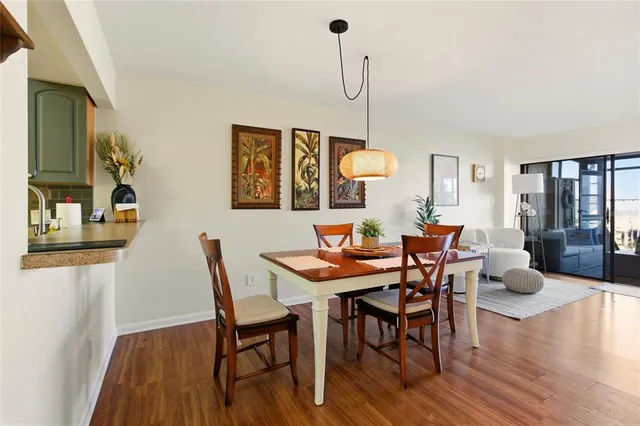 a dining room with furniture a chandelier and wooden floor