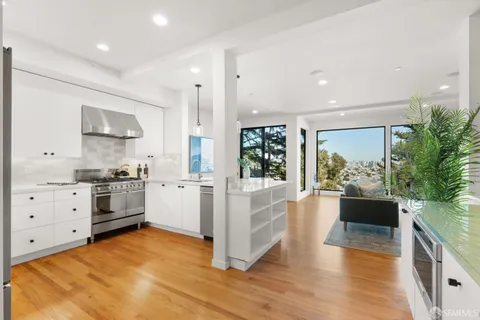 a kitchen with stainless steel appliances granite countertop a stove a sink and white cabinets