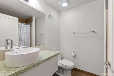 a bedroom with a large bed and a lamp