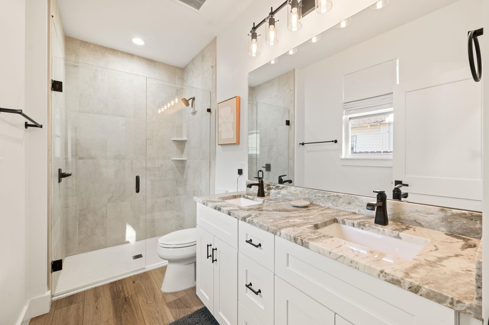 135 Blanco Street St. Augustine, FL 32084 - Photo 20 of 35 a bathroom with a granite countertop sink a toilet a shower and a mirror