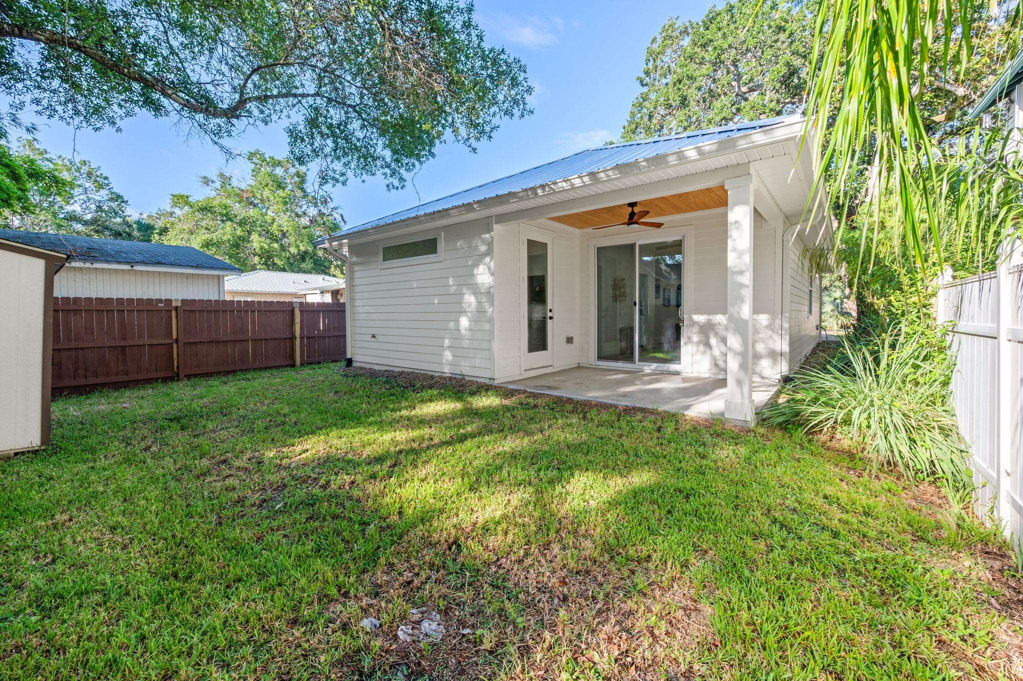 135 Blanco Street St. Augustine, FL 32084 - Photo 31 of 35 a view of a house with a small yard and wooden fence