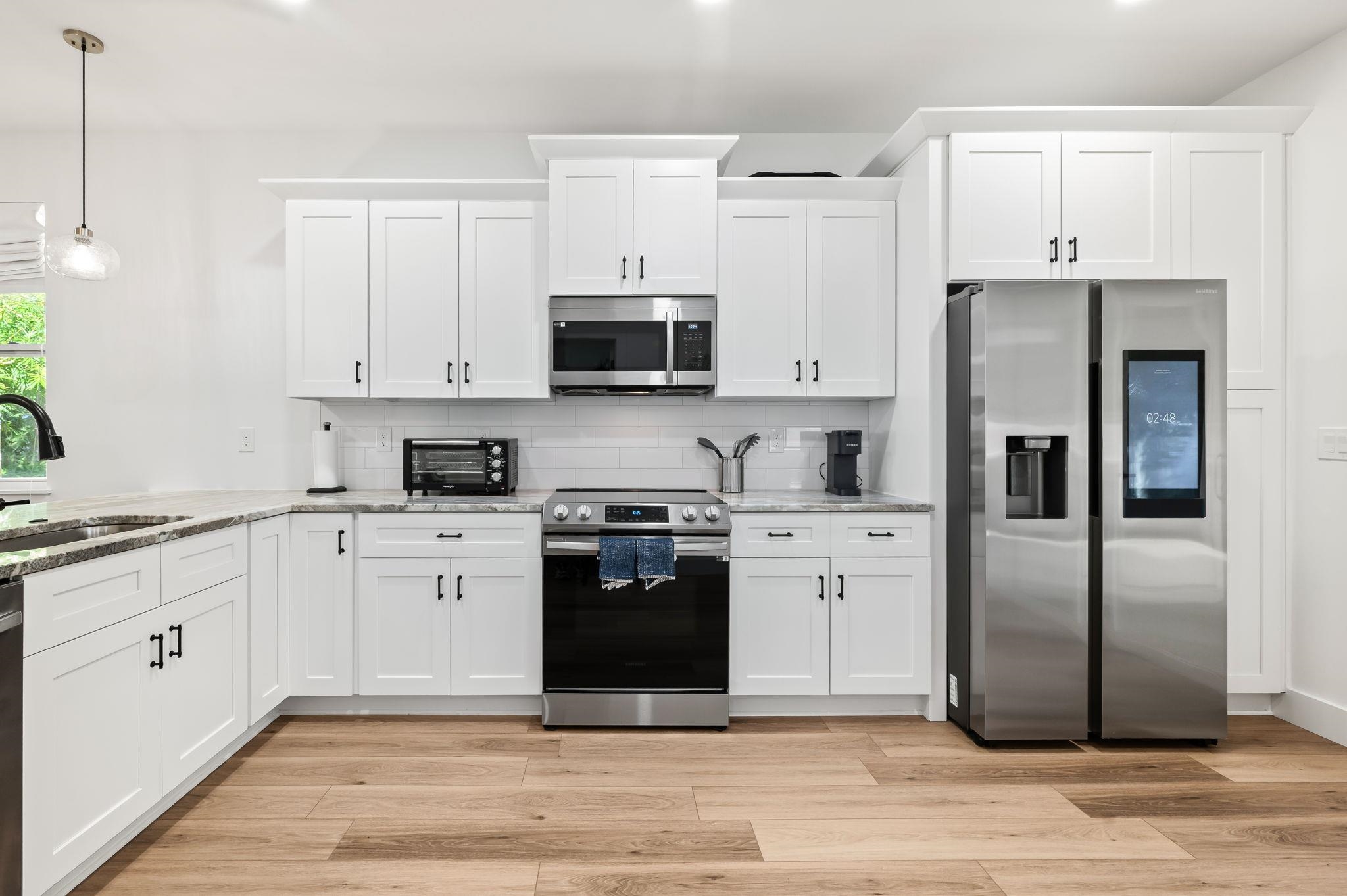 135 Blanco Street St. Augustine, FL 32084 - Photo 8 of 35 a kitchen with granite countertop a refrigerator stove and white cabinets