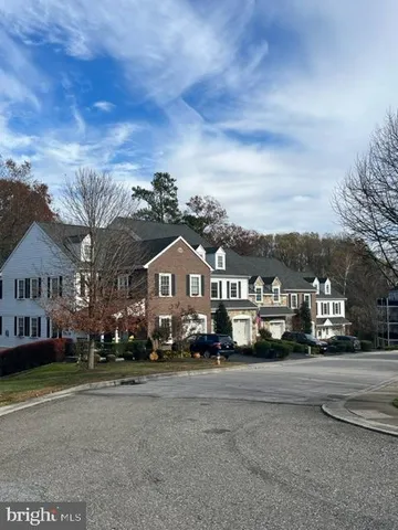 a brick building with a big yard and large trees