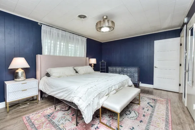 a bedroom with a bed and a lamp with window