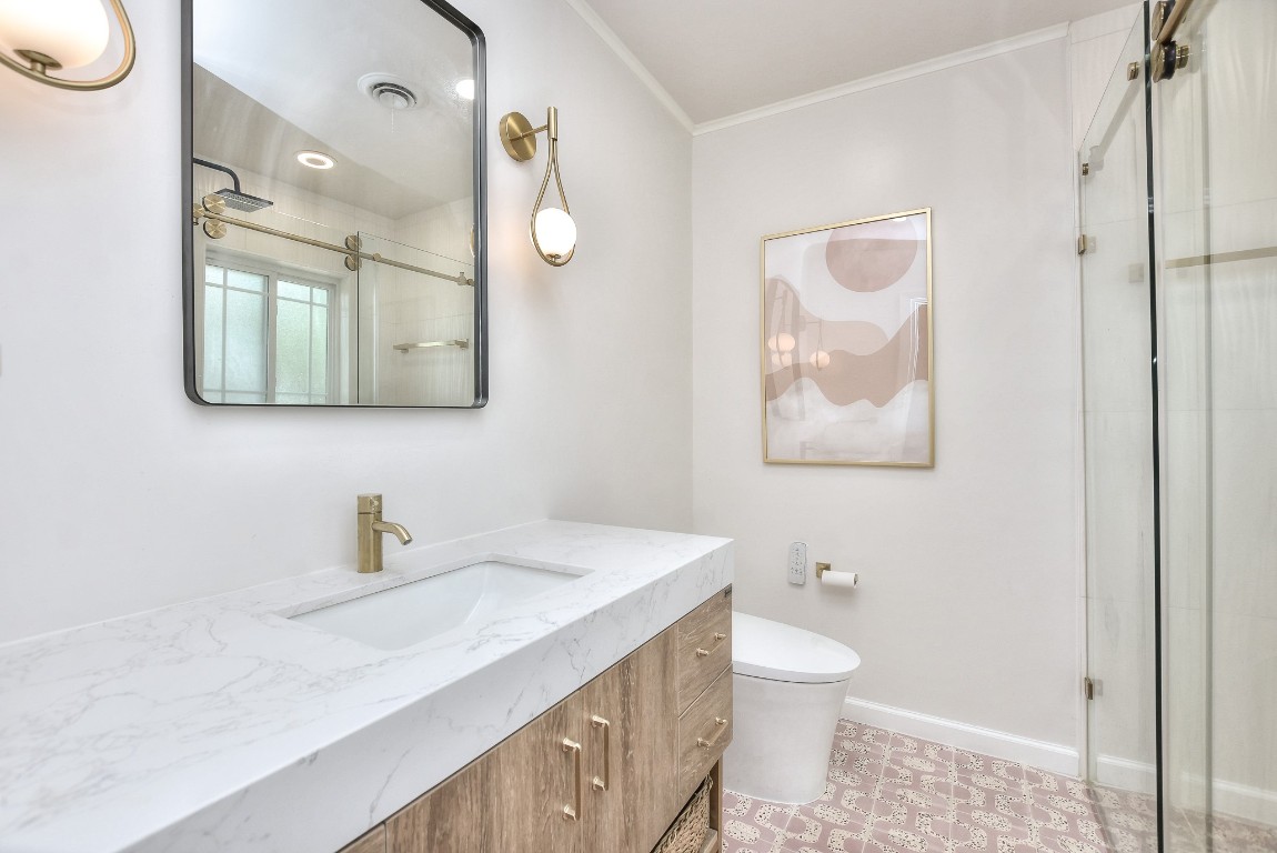 1407 East 19th Street Georgetown, TX 78626 - Photo 17 of 36 a bathroom with a toilet a sink a mirror and a shower