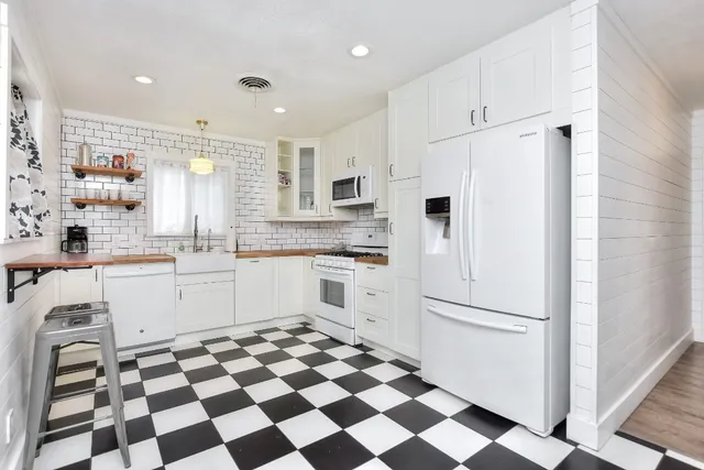 a kitchen with stainless steel appliances a sink a stove a microwave and cabinets