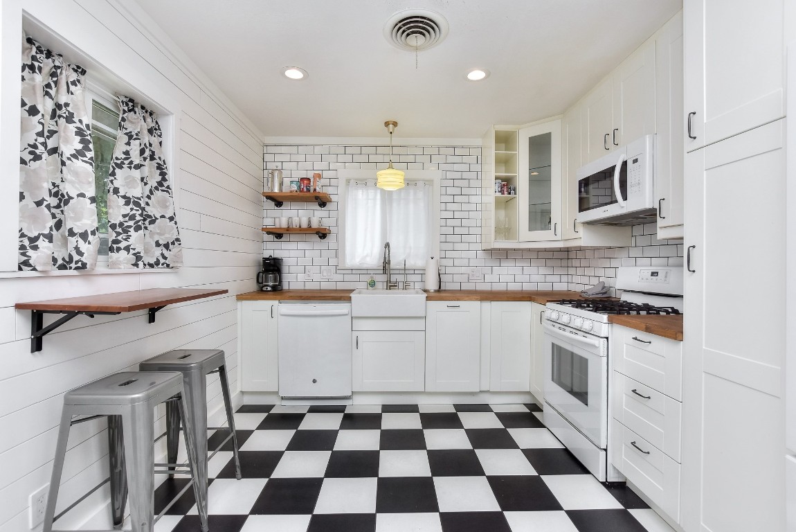 1407 East 19th Street Georgetown, TX 78626 - Photo 21 of 36 a kitchen with stainless steel appliances a sink a stove a microwave and cabinets