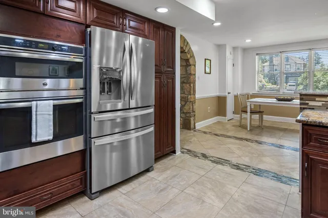 a kitchen with stainless steel appliances granite countertop a refrigerator and a stove top oven