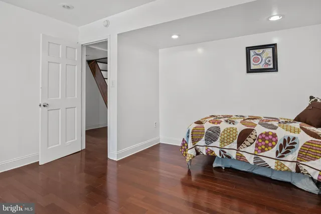 an empty room with wooden floor closet and windows