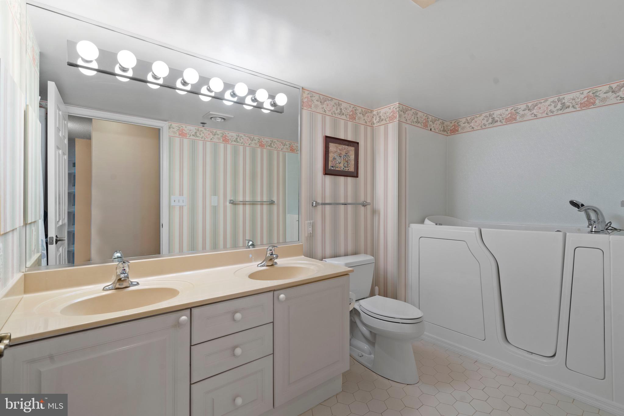 19385 Cypress Ridge Terrace, Unit 914 Leesburg, VA 20176 - Photo 20 of 39 a bathroom with a double vanity sink mirror and toilet