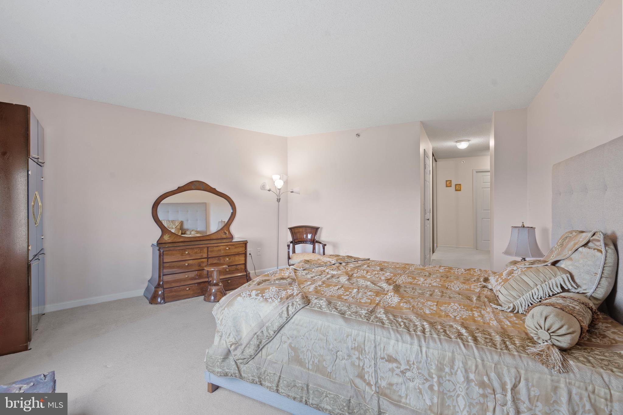 19385 Cypress Ridge Terrace, Unit 914 Leesburg, VA 20176 - Photo 21 of 39 a bedroom with a bed and a chair