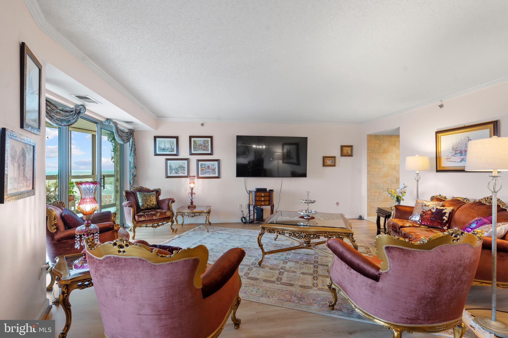 19385 Cypress Ridge Terrace, Unit 914 Leesburg, VA 20176 - Photo 6 of 39 a living room with furniture potted plant and a flat screen tv
